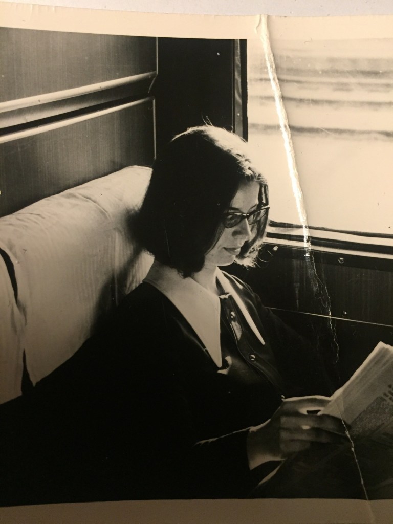 Photo of a young Susan Ostrov reading on the train